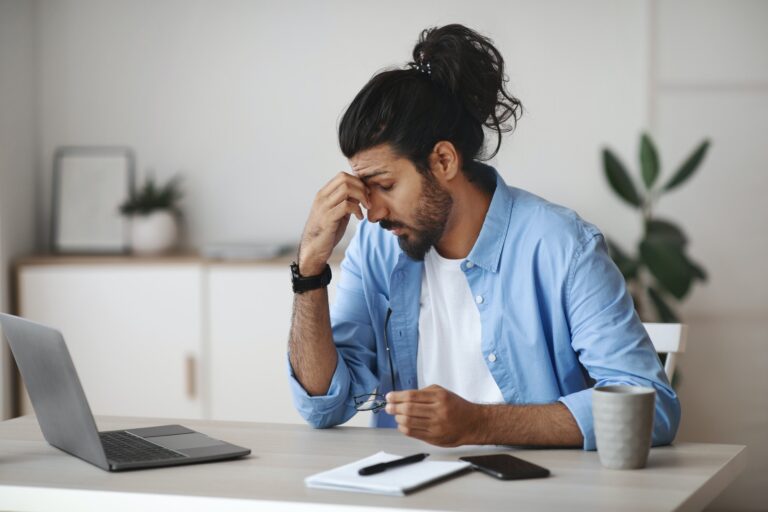 Eyes Fatigue. Stressed Indian Man Tired After Working On Laptop In Office